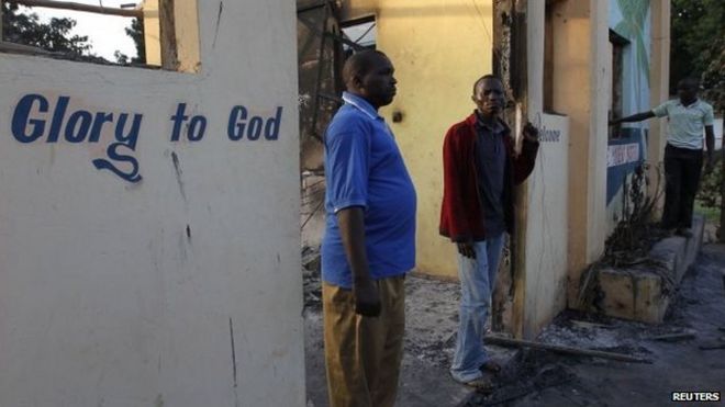 Жители Кибаони смотрят на руины сгоревшего отеля Breeze View после того, как неизвестные вооруженные люди напали на прибрежный кенийский город Мпекетони 16 июня 2014 года.