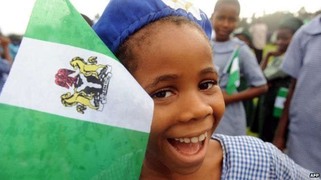 Нигерийская студентка улыбается, присутствуя на праздновании Дня независимости в Лагосе 1 октября 2013 г.