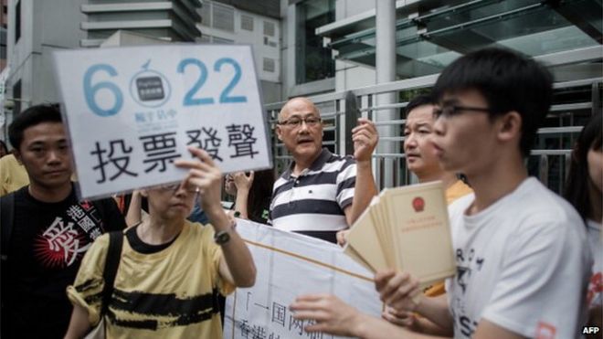 Демонстранты, поддерживающие движение Occupy Central, демонстрируют плакаты, на которых жители просят проголосовать Жители Гонконга имели несколько дней, чтобы проголосовать в неофициальном опросе