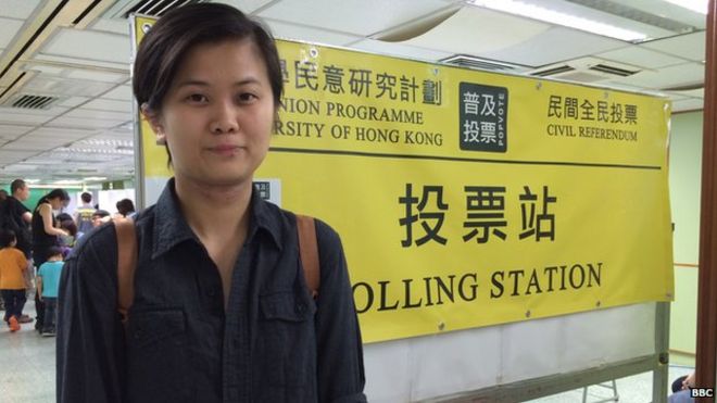 Финансовый аналитик Натали Чен позирует возле избирательного участка в Гонконге