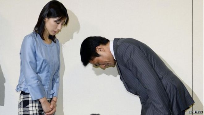 Законодатель Токийского городского собрания Акихиро Судзуки (справа) кланяется, чтобы принести извинения законодателю Аяке Шиомуре в столичной мэрии Токио на этой фотографии, сделанной Киодо 23 июня 2014 года.