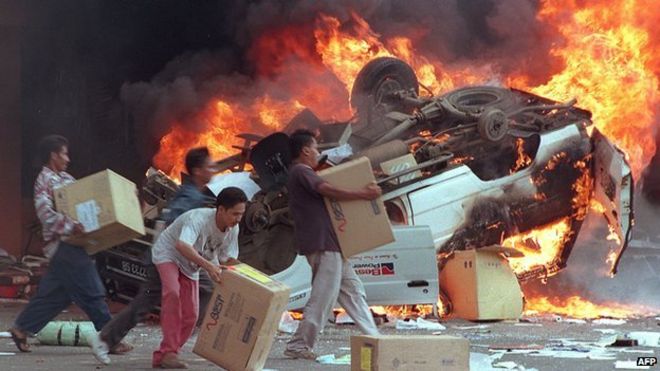 Разъяренные индонезийские толпы сжигают автомобили и китайские магазины, когда они грабили магазины в Джакарте 14 мая 1998 года