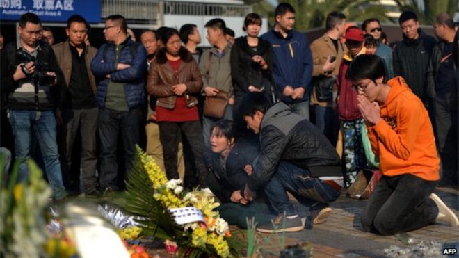 На этом снимке, сделанном 7 марта 2014 года, изображены родственники, оплакивающие жертв на месте теракта на главном железнодорожном вокзале в Куньмине, провинция Юньнань на юго-западе Китая.