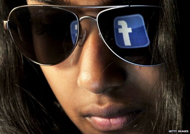 Женщина с логотипом Facebook отражается на ее солнцезащитных очках