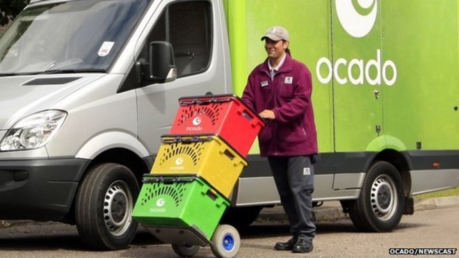 Работник службы доставки Ocado с ящиками и фургоном
