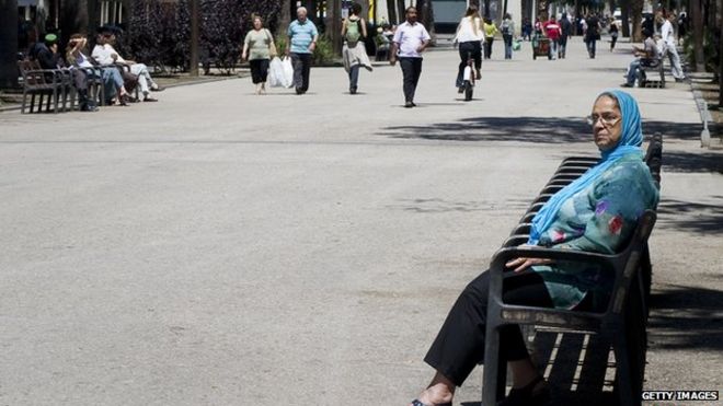 Завуалированная женщина сидит на скамейке в Барселоне 16 июня 2010 года.