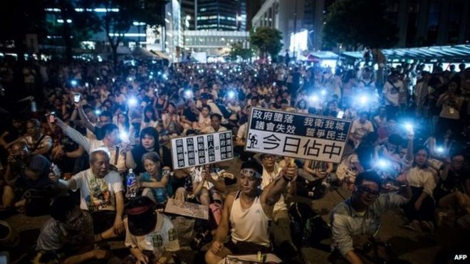 Демонстранты сидят на улице центрального района после митинга за демократию в Гонконге 1 июля 2014 года