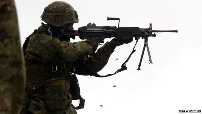 Солдаты из пехотного полка Западной армии сухопутных войск Японии стреляют боевыми патронами во время совместных учений с морскими пехотинцами и моряками США 9 февраля 2014 года