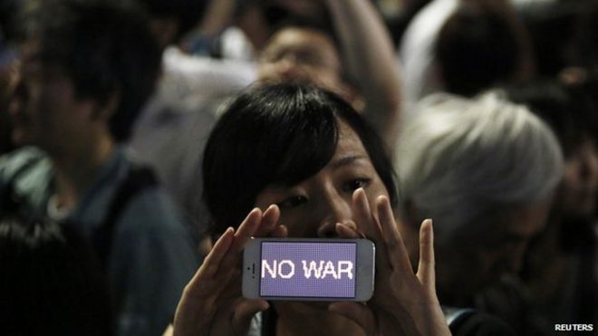 Протестующий держит свой смартфон с надписью «НЕТ ВОЙНЫ». на митинге против попытки премьер-министра Японии Синдзо Абэ расширить военную роль Японии перед официальной резиденцией Абэ в Токио 1 июля 2014 года