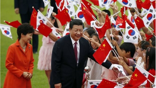 Президент Китая Си Цзиньпин (справа) и его южнокорейский коллега Пак Кын Хе (слева) приветствуют детей во время церемонии приветствия в Президентском голубом доме в Сеуле, Южная Корея, 3 июля 2014 года.