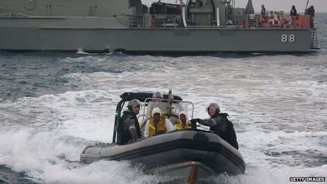 Персонал австралийских ВМС переправляет лиц, ищущих убежища, на индонезийскую спасательную лодку возле острова Панайтан, Западная Ява 31 августа 2012