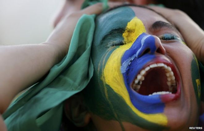 Фанатка Бразилии держит голову в отчаянии во время полуфинального поражения от Германии