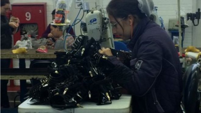 женщина работает на бразильской обувной фабрике
