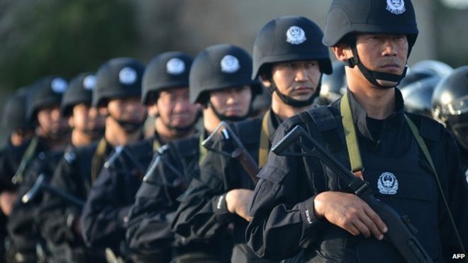 Антитеррористические силы, включая полицию общественной безопасности и вооруженную полицию, участвуют в совместных учениях по борьбе с терроризмом в Хами, регион Синьцзян на северо-западе Китая, 2 июля 2014 года