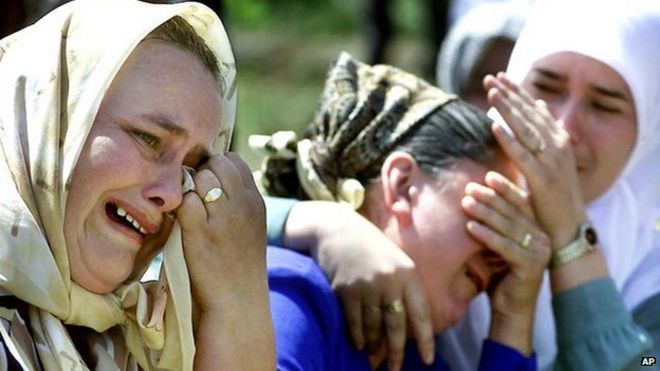Боснийские мусульманки плачут во время церемонии, посвященной 6-й годовщине резни в Сребренице, в деревне Потокари, недалеко от Сребреницы, 11 июля 2001 года.