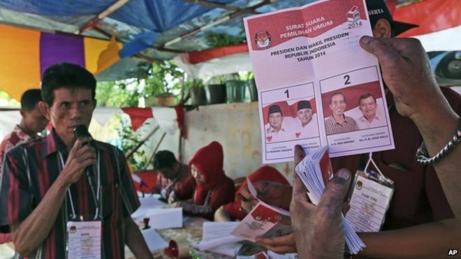 Избиратель показывает избирательный бюллетень с голосами за кандидата в президенты Джоко Видодо во время подсчета голосов на избирательном участке в Джакарте, Индонезия, в среду, 0 июля 2014 года