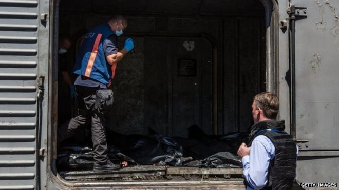 Голландские следователи и наблюдатели ОБСЕ осматривают тела в Торезе. Фото: 21 июля 2014 г.