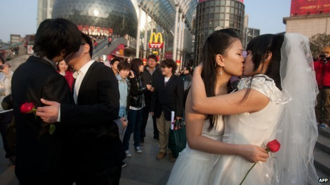 На снимке, сделанном 8 марта 2011 года, однополые пары целуются во время их церемониальной «свадьбы», пытаясь повысить осведомленность о проблеме гомосексуальных браков в Ухане, в провинции Хубэй, в центральном Китае