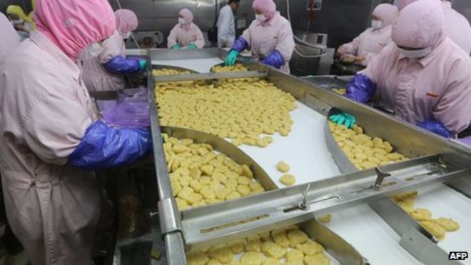 Рабочие, перерабатывающие мясо в Shanghai Husi Food Co