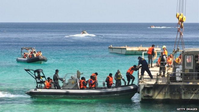 Подозреваемые в поиске убежища прибывают на остров Рождества после получения помощи от ВМС Австралии 13 октября 2012 года на острове Рождества.