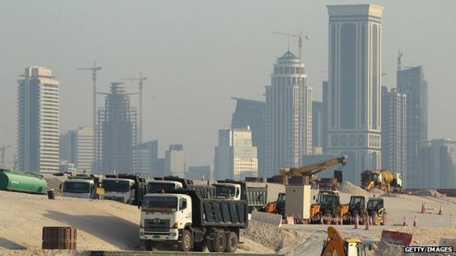 Грузовики стоят на строительной площадке напротив небоскребов в зарождающемся новом финансовом районе в Дохе, Катар - 26 октября 2011 года
