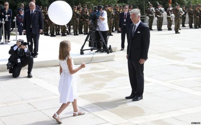 Король Бельгии Филипп вручает воздушный шар девушке, одетой в белое в Льеже