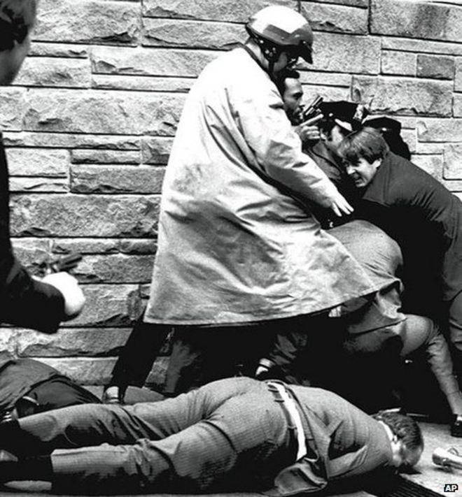 Джеймс Брэди, пресс-секретарь президента Рейгана, лежит раненым на тротуаре возле отеля в Вашингтоне, округ Колумбия 30 марта 1981 г.
