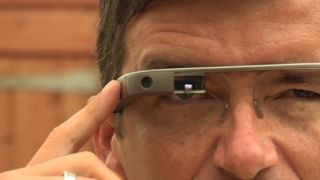 Крупный план Уильяма, одетого в Google Glass. Стеклянный экран идет прямо через глаз, и он нажимает кнопку на боковой стороне стекла