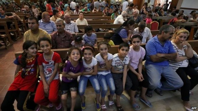 Иракские христиане, бежавшие от насилия в деревне Каракуш, примерно в 30 километрах к востоку от северной провинции Ниневия, сидят в церкви Святого Иосифа в курдском городе Эрбиль