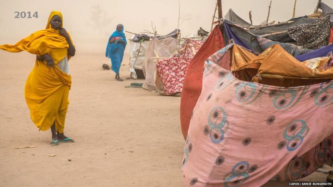 Женщины, изображенные во время пыльной бури в поселении для тех, кто только что прибыл в Хамадиа Кампен, Дарфур, Судан - 2014