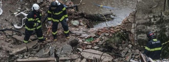 Сотрудники аварийно-спасательных служб на месте падения самолета в Сантосе, штат Сан-Паулу, Бразилия, 13 августа 2014 года.