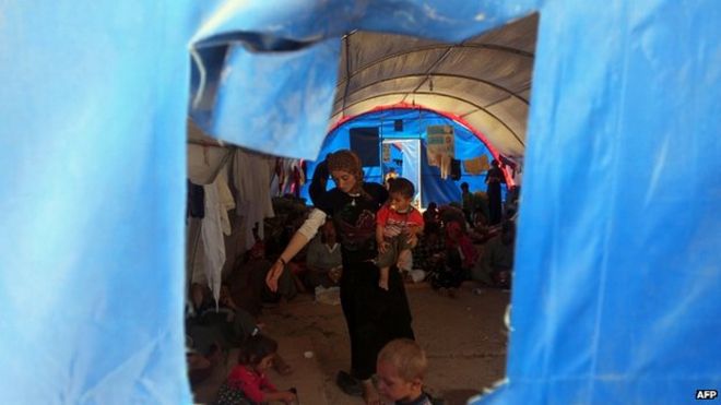 Перемещенные иракские езиды, бежавшие от нападения джихадистов на Синджар, стоят в палатке после того, как они нашли убежище в лагере Баджид Кандала в провинции Дохук 13.08.2014