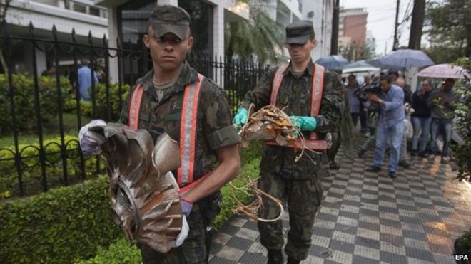 Солдаты убирают обломки с места падения самолета в жилом районе На Руа Вахия де Абреу в Сантосе (13 августа 2014 года)