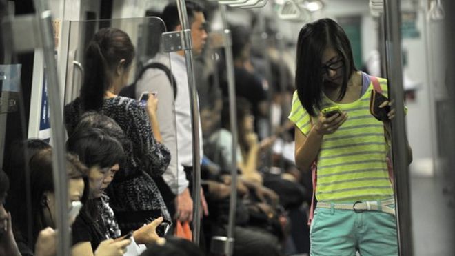 Люди проверяют телефоны на поезд Сингапура