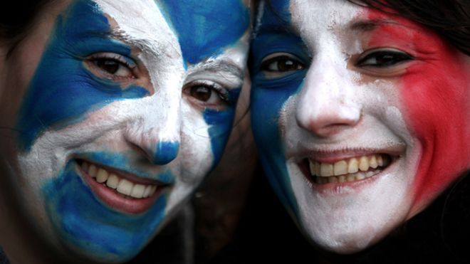 Два человека раскрашены лицом с шотландскими и французскими флагами
