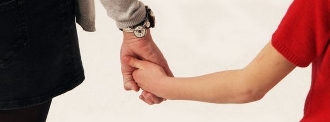 Родитель и ребенок держатся за руки