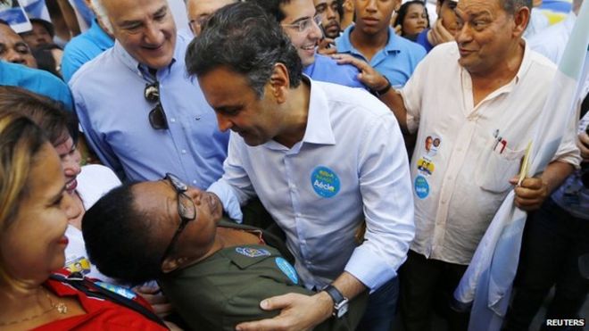 Кандидат в президенты Аесио Невес приветствует сторонника во время митинга в Рио-де-Жанейро. 25 августа 2014 года
