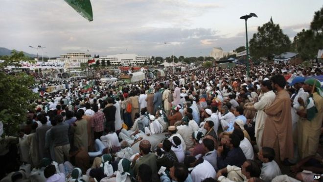 Тысячи сторонников Тахир-уль-Кадри слушают своего лидера во время сидячей акции протеста возле здания парламента в Исламабаде (28 августа 2014 года)