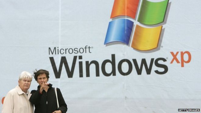 Женщины перед плакатом Windows XP
