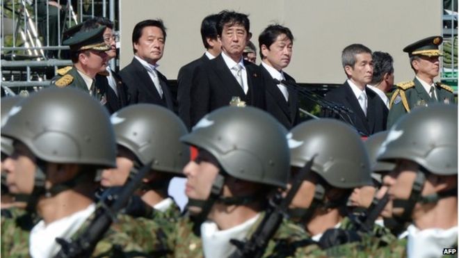 На этом снимке, сделанном 27 октября 2013 года, видно, что премьер-министр Японии Синдзо Абэ (вверху в центре) осматривает войска Сил самообороны Японии во время военного обзора на полигоне Асака сухопутных сил самообороны, пригород Токио