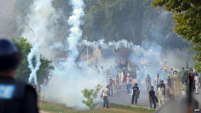 Пакистанские демонстранты стоят среди слезоточивого газа во время столкновений с полицией в Исламабаде. Фото: 31 августа 2014 г.