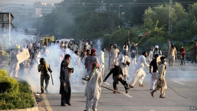 Сторонники пакистанского мусульманского священнослужителя Тахирула Кадри и оппозиционного политика Имрана Хана сталкиваются с полицией во время антиправительственной акции протеста в Исламабаде, Пакистан, 1 сентября 2014 года.