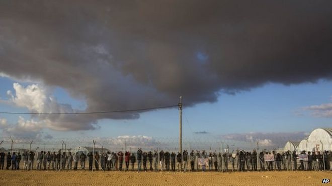 Африканские мигранты стоят внутри объекта Холот в израильской пустыне Негев (17 февраля 2014 года)