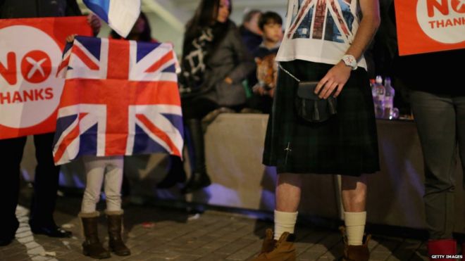 Люди машут флагом Нет возле шотландского парламента