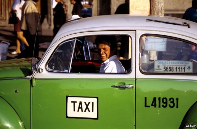 Водитель такси в одном из характерных зеленых VW жуков Мехико