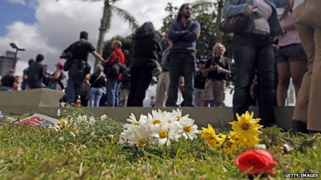 Люди возлагают цветы для демонстрации против насилия и высокого уровня убийств в Венесуэле 12 января 2014 года.