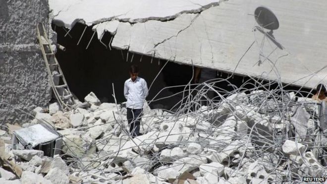 Житель идет по обломкам зданий, которые были повреждены в результате, как говорят активисты, одного из американских авиаударов во вторник в Кфредриане, провинция Идлиб, 24 сентября 2014 года