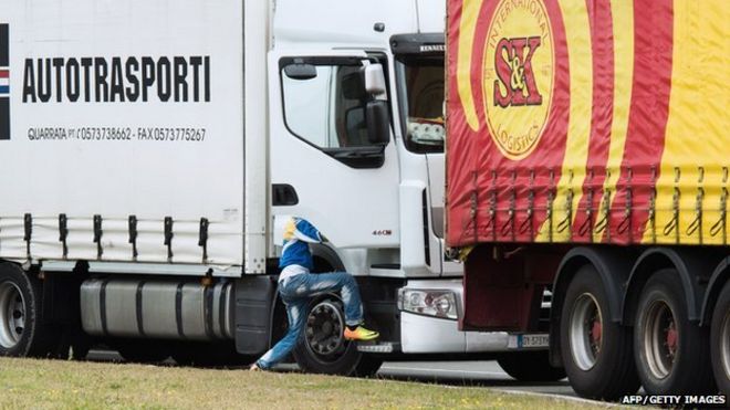 Незаконный мигрант въезжает в грузовик, едущий в Великобританию 10 сентября 2014 года во французском порту Кале