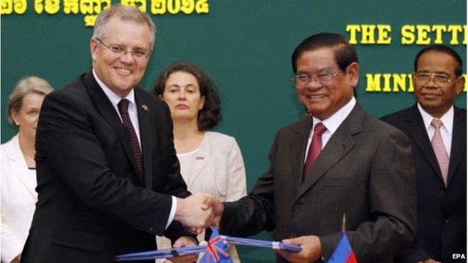 Скотт Моррисон (слева), министр иммиграции Австралии, пожимает руку с Сар Хенг (справа), заместителю премьер-министра Камбоджи и министру внутренних дел, во время церемонии подписания в Пномпене, Камбоджа, 26 сентября 2014 года