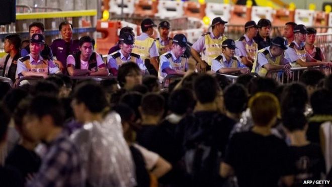 Полиция наблюдает, как протестующие собираются перед церемонией, посвященной 65-му национальному дню Китая в Гонконге 1 октября